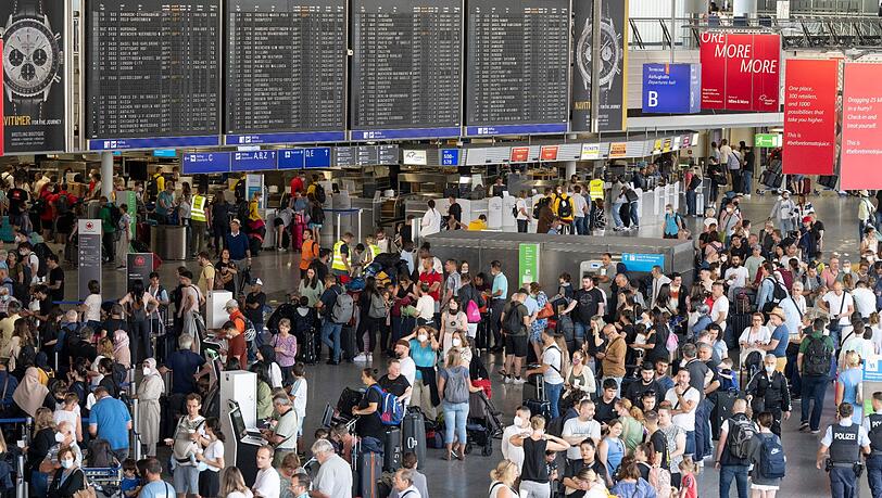 Tausende Passagiere warten vor den Abfertigungsschaltern des Flughafens auf ihren Check-In.