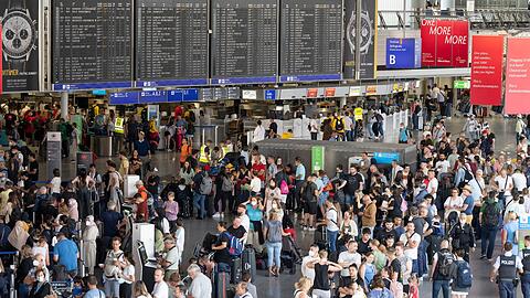Tausende Passagiere warten vor den Abfertigungsschaltern des Flughafens auf ihren Check-In.