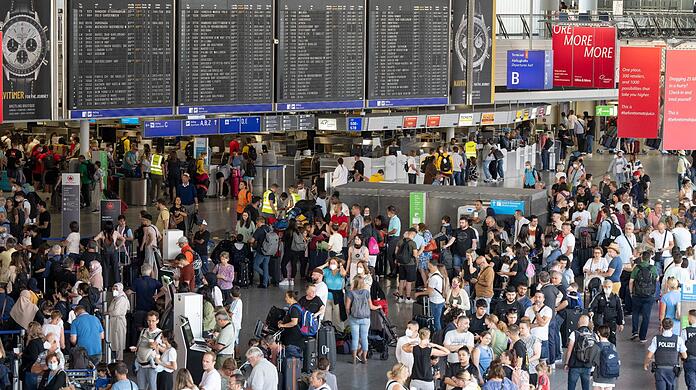 Tausende Passagiere warten vor den Abfertigungsschaltern des Flughafens auf ihren Check-In.