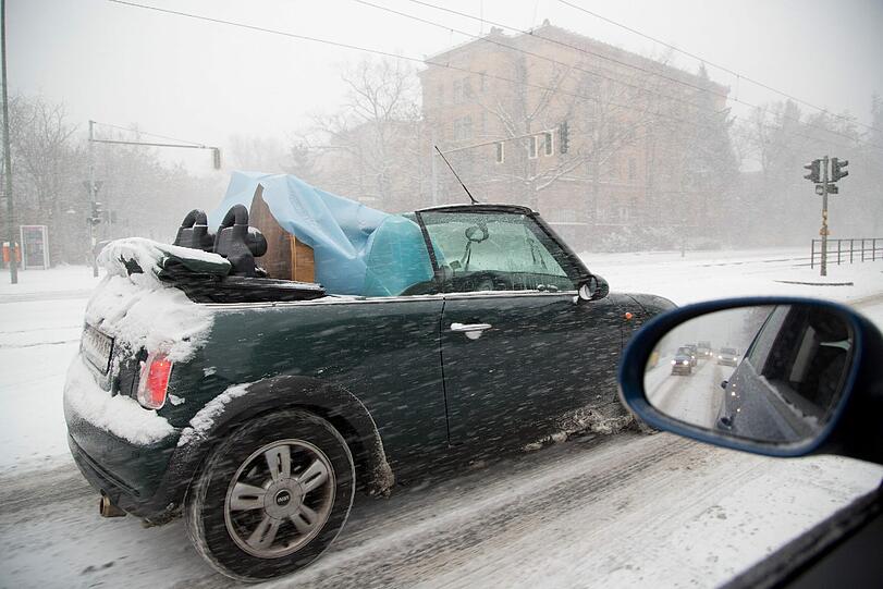 ... in diesem Mini-Cabrio wird offen ein Tisch transportiert, während ein Schneesturm wütet.