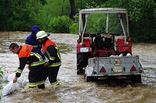 Feuerwehrleute arbeiten am 10.06.2013 im Hochwasser in Kumbach im Landkreis Günzburg (Bayern). Heftige Regenfälle haben die Wasserstände an den Donauzuflüssen in Schwaben rasant ansteigen lassen.