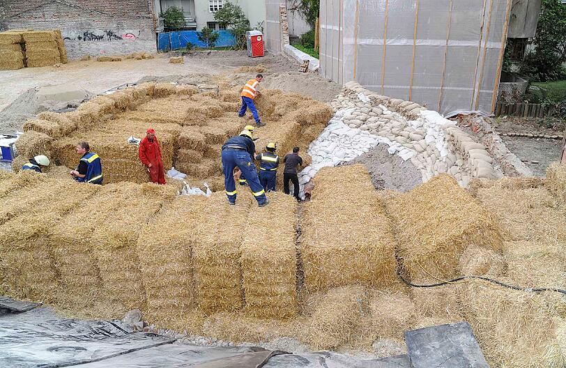 Mit Sandsäcken und einem Wall aus Stroh wird die Schwabinger Bombe zugedeckt.