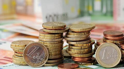 Euro-Münzen auf Euro-Banknoten. Foto: Tobias Hase/dpa/Symbolbild