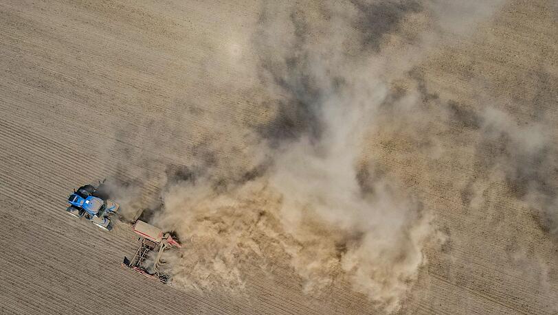 Ein brandenburgischer Landwirt fährt über seinen trocken Ackerboden. Dort gab es viele Wochen lang keinen Niederschlag.