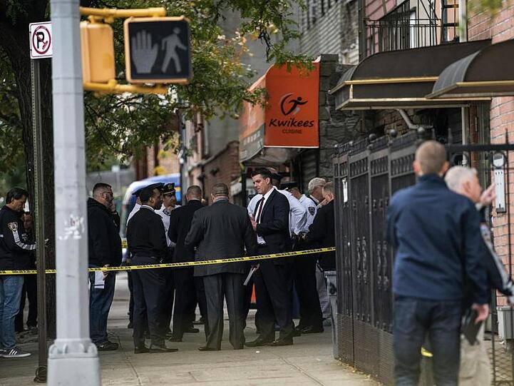Polizisten stehen vor dem Haus in New York, in dem vier Menschen starben und drei verletzt wurden.