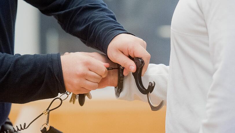 Ein Justizbeamter nimmt dem Angeklagten im Landgericht in Hannover Handschellen ab. Foto: Julian Stratenschulte Ein Justizbeamter nimmt dem Angeklagten im Landgericht in Hannover Handschellen ab. Foto: Julian Stratenschulte