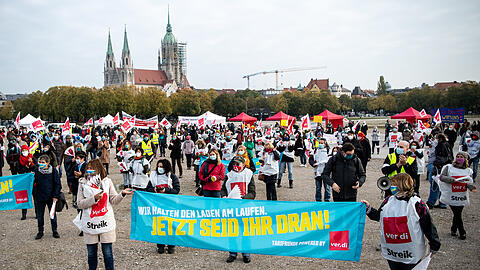 19.10.2020, Bayern, München: Demonstrationsteilnehmer stehen mit einem Banner mit der Aufschrift "Wir halten den Laden am laufen - jetzt seid ihr dran!" auf einer Streikkundgebung auf der Theresienwiese während des Warnstreiks im öffentlichen Dienst.