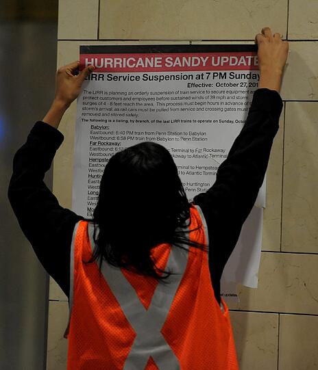 Eine Mitarbeiterin hängt Informationsplakate und Warnhinweise in der U-Bahn auf. Der öffentliche Verkehr in New York wird bei Ankunft von Sandy still stehen.