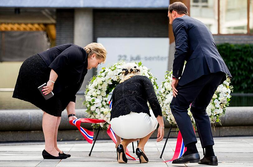 Im Osloer Regierungsviertel legen Ministerpräsidentin Erna Solberg (l) und das norwegische Kronprinzenpaar, Mette-Marit und Haakon, Kränze für die Brevik-Opfer nieder. Foto: Vegard Wivestad Groett