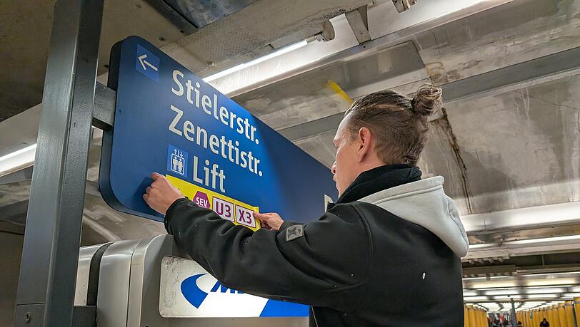 Ein Mitarbeiter der MVG befestigt Aufkleber, die zum Schienenersatzverkehr weisen: Den Fahrgästen der Linien U3 und U6 ist dieser Anblick vertraut. In den letzten Jahren mussten sie immer wieder zum Teil auf Ersatzbusse umsteigen.