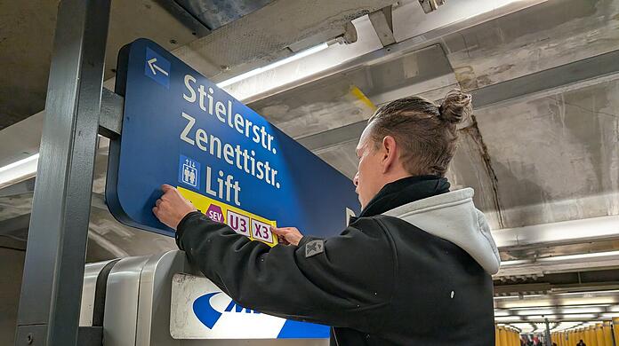Ein Mitarbeiter der MVG befestigt Aufkleber, die zum Schienenersatzverkehr weisen: Den Fahrgästen der Linien U3 und U6 ist dieser Anblick vertraut. In den letzten Jahren mussten sie immer wieder zum Teil auf Ersatzbusse umsteigen.