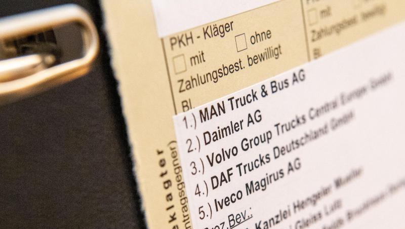 Akten mit den Namen der beklagten Firmen und ihrer Anwälte stehen vor Beginn des Prozesses im Gerichtssaal. Foto: Lino Mirgeler/dpa/Archivbild Akten mit den Namen der beklagten Firmen und ihrer Anwälte stehen vor Beginn des Prozesses im Gerichtssaal. Foto: Lino Mirgeler/dpa/Archivbild