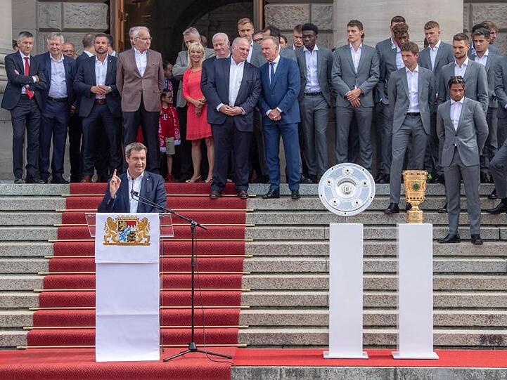 Ministerpräsident Söder (CSU,l) empfängt im Hofgarten die Mannschaft des FC Bayern München. Foto: Peter Kneffel