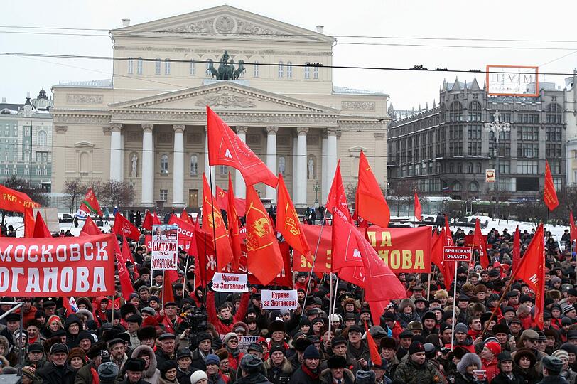 Während der Pro-Putin Demo, versammelten sich Tausende,um gegen den Kremlkandidaten zu protestieren. Anhänger der Oppositionspartei "Kommunistische Partei der Russischen Föderation" (KPRF) hielten Banner mit "Russia - without Putin" hoch oder stellten Putin als Adolf Hitler dar.