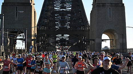 Mehr als 40.000 L&auml;ufer bahnen sich beim Sydney-Marathon 2025 in Sydney ihren Weg &uuml;ber die Sydney Harbour Bridge. Am Ende erhalten sie zur Belohnung die Finisher-Medaille.