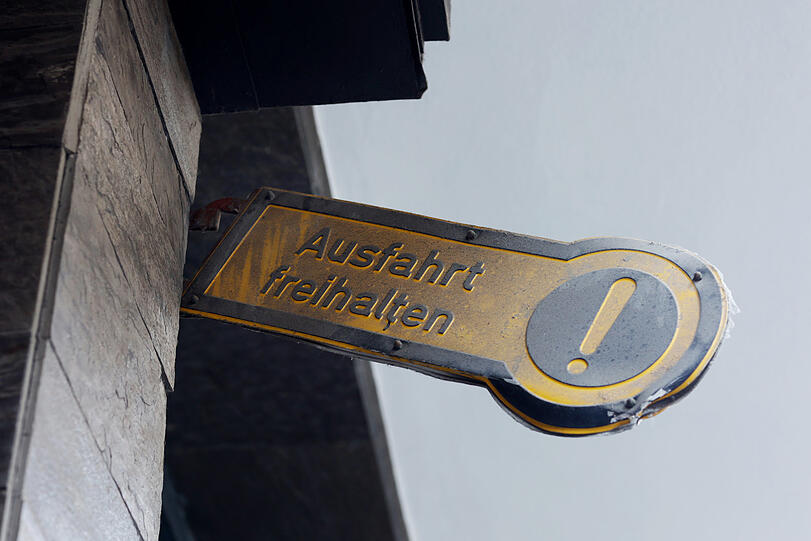Ein altes Ausfahrtschild hängt hier auf halb zwölf.