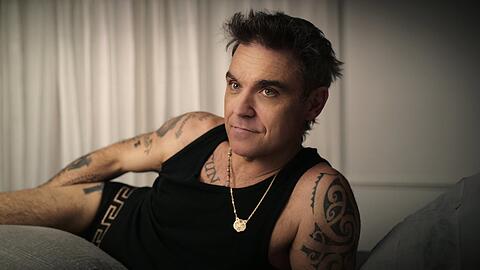 Daheim im Bett liegend gibt er Intimes preis: Der britische Popstar Robbie Williams in einer Szene der Netflix-Miniserie "Robbie Williams".