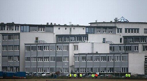 Airbus-Mitarbeiter gehen am 28.11.2013 in Hamburg auf dem Airbus-Werksgelände in Finkenwerder vor den Fertigungshallen entlang. Die Beschäftigten protestieren bundesweit bei einem Aktionstag der EADS gegen Pläne für einen massiven Stellenabbau im Rüstungsgeschäft.