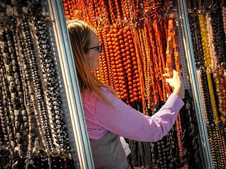 Eine Besucherin der Messe Inhorgenta Munich schaut sich Schmuck an. Foto: Sina Schuldt/dpa/Archivbild