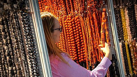 Eine Besucherin der Messe Inhorgenta Munich schaut sich Schmuck an. Foto: Sina Schuldt/dpa/Archivbild