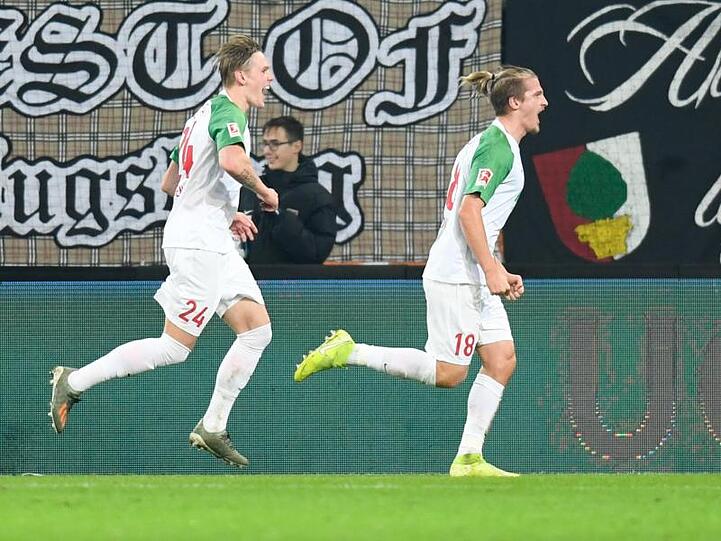 Tin Jedvaj vom FC Augsburg jubelt mit Fredrik Jensen (l). Foto: Tom Weller/dpa/Archivbild