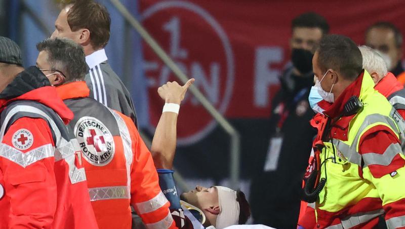 Der Nürnberger Tom Krauß (M) wird verletzt aus dem Stadion getragen, zeigt aber mit dem Daumen nach oben.