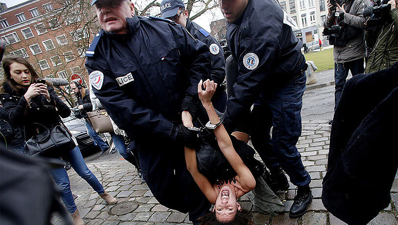 Eine Femen-Aktivistin wird von der Polizei festgenommen. Sie ist zuvor auf das Auto von Strauss-Kahn gestiegen. Eine Femen-Aktivistin wird von der Polizei festgenommen. Sie ist zuvor auf das Auto von Strauss-Kahn gestiegen.