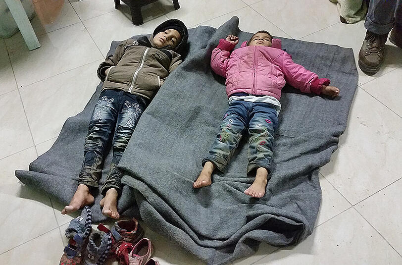 Dieser syrische Bub (l.) und seine Schwester haben auf der Straße geschlafen. Die Ärzte haben ihnen vor dem Heizlüfter ein Notbett bereitet.