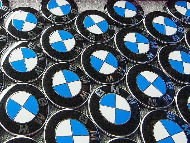 BMW-Embleme liegen in der Produktion im BMW-Werk in Dingolfing (Bayern) in einer Kiste. Foto: Armin Weigel/dpa/Archivbild