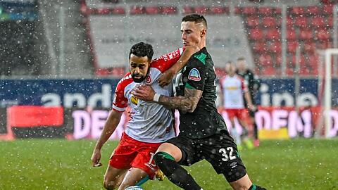 Marco Friedl von Werder (r) und Sarpreet Singh von Regensburg kämpfen um den Ball.