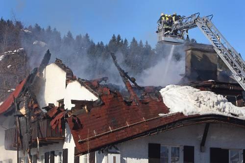 Feuerwehrleute löschen im Zentrum von Oberstaufen letzte Brandherde eines Großfeuers.