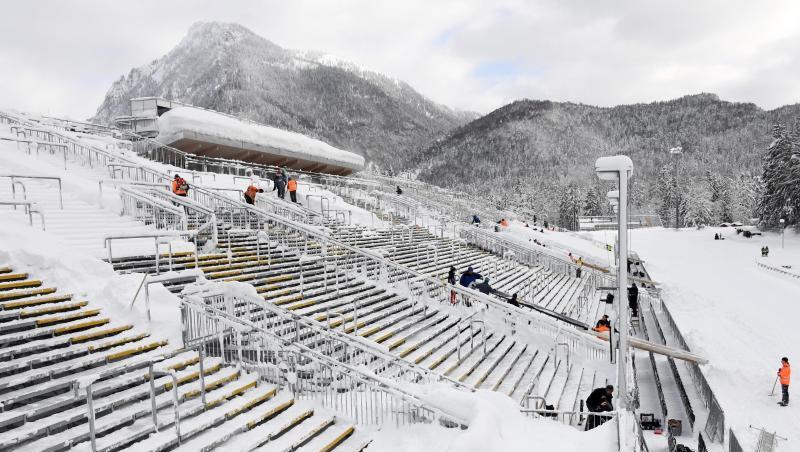 Helfer befreien die Zuschauertribühne in der Chiemgau-Arena in Ruhpolding von den Schneemassen. Helfer befreien die Zuschauertribühne in der Chiemgau-Arena in Ruhpolding von den Schneemassen.