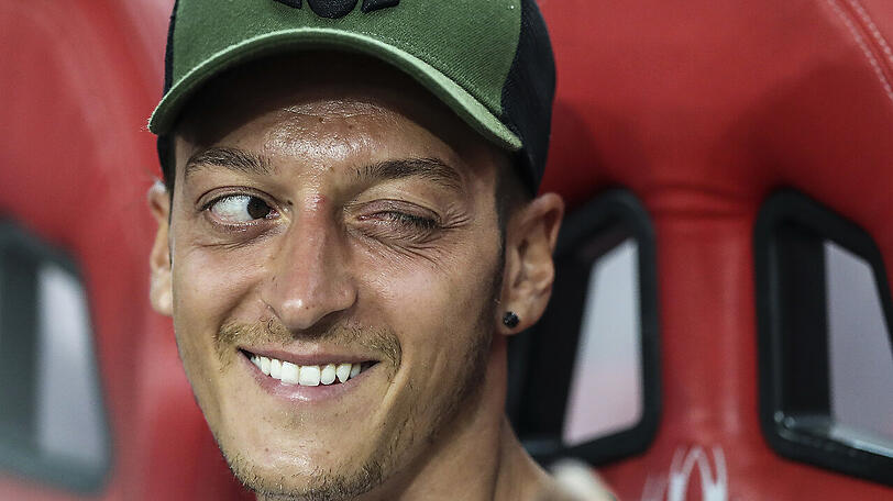 Mesut Özil vom FC Arsenal sitzt auf der Bank.