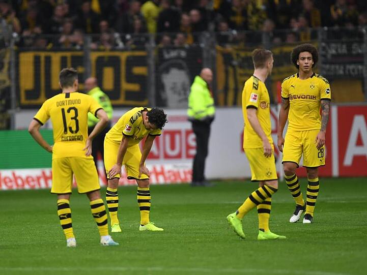 Sind sich selbst ein Rätsel: Die BVB-Spieler stehen nach dem Remis beim SC Freiburg mit hängenden Köpfen auf dem Spielfeld.