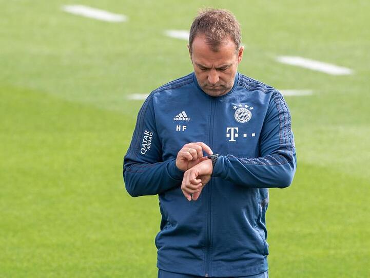 Trainer Hansi Flick schaut bei einer Übungseinheit am Vormittag auf die Uhr. Foto: Peter Kneffel/dpa