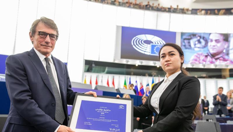 Jewher Ilham nimmt für ihren Vater den Sacharow-Preis aus den Händen des Präsidenten des Europäischen Parlaments, David Sassoli, entgegen. Im Hintergrund ist ein Foto von Ilham Tohti zu sehen. Jewher Ilham nimmt für ihren Vater den Sacharow-Preis aus den Händen des Präsidenten des Europäischen Parlaments, David Sassoli, entgegen. Im Hintergrund ist ein Foto von Ilham Tohti zu sehen.