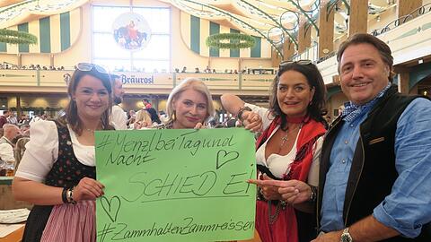 Nancy (v.l.), Ulrike, Simone und Günther halten in der Bräurosl-Festhalle ein Plakat mit Herzen für die Kapelle Josef Menzl in die Höhe - bei dieser Aktion allein wird es nicht bleiben.
