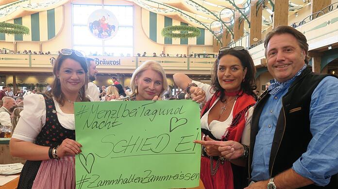 Nancy (v.l.), Ulrike, Simone und Günther halten in der Bräurosl-Festhalle ein Plakat mit Herzen für die Kapelle Josef Menzl in die Höhe - bei dieser Aktion allein wird es nicht bleiben.