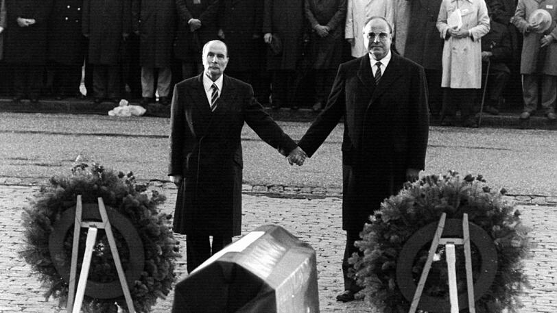 22. September 1984:  Wieder das deutsch-französische Verhältnis, wieder ein Bild für die Geschichtsbücher: Der französische Präsident  François Mitterrand  (l), und Kanzler Helmut Kohl reichen einander über den Gräbern von Verdun die Hand - ein Symbol für die Aussöhnung zwischen Frankreich und Deutschland.