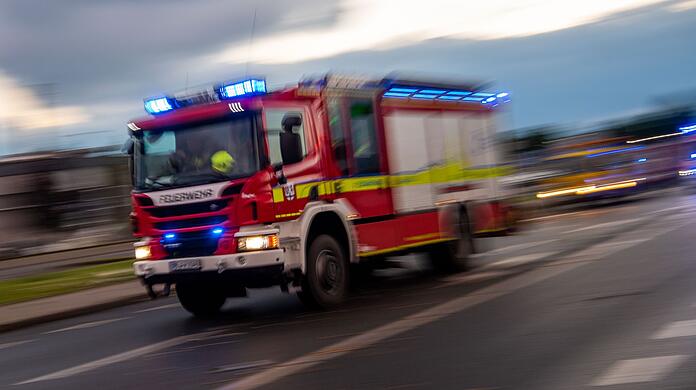 Ein Löschfahrzeug der Feuerwehr fährt mit Blaulicht zu einem Einsatz.