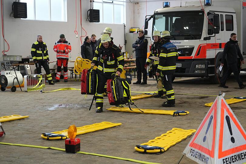 Die Berufsfeuerwehr unterstützt die Notfallsanitäter mit zusätzlichen Tragen und kümmert sich um die Absperrung.
