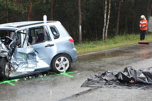 Das Wrack eines Pkw und ein abgedeckter Leichnam liegen am Sonntag (04.07.2010) auf der Bundesstraße bei Dolle in Sachsen-Anhalt.