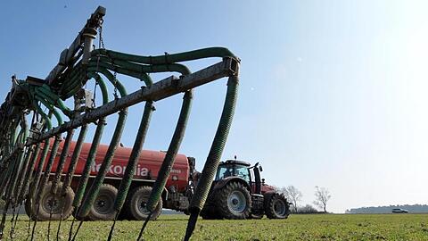 Ein Landwirt verteilt Gülle auf einem Feld. Foto: Philipp Schulze/dpa/Archiv