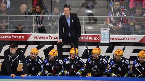 Thomas Popiesch (M,oben), Trainer der Pinguins Bremerhaven, verfolgt das Spiel.