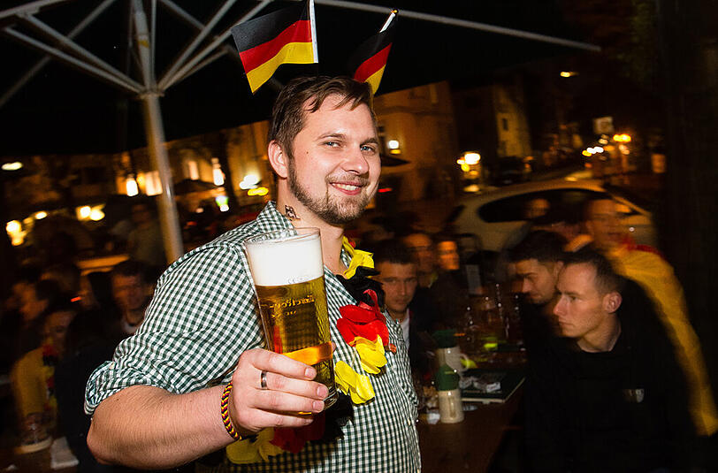 Kellner und Fußballfan Jan-Hendrik Hagemeister verfolgt beim Public Viewing in einem Biergarten in München das Spiel.
