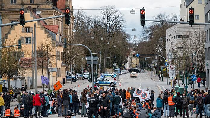 Aktivistinnen und Aktivisten der Letzten Generation blockieren eine Kreuzung in Regensburg.