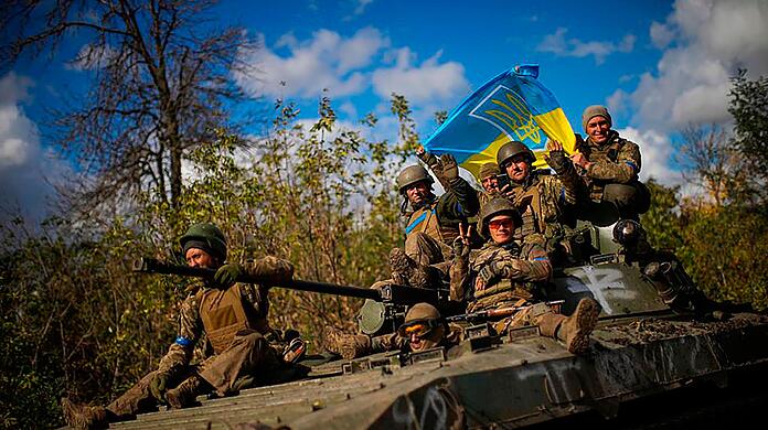 Ukrainische Soldaten fahren eine Straße zwischen Isjum und Lyman entlang.