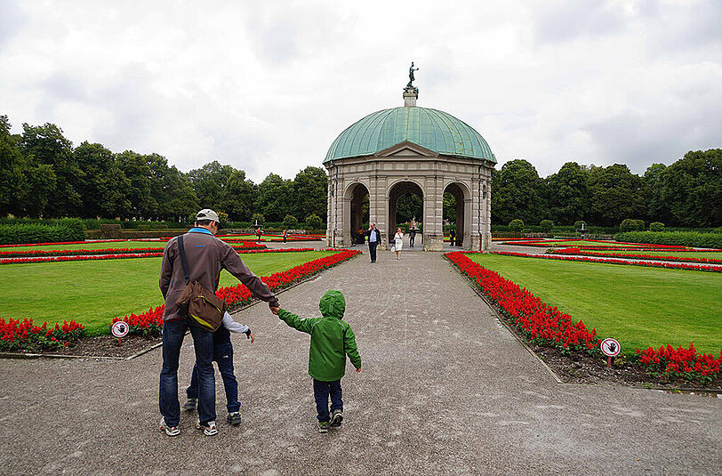 Trotz des durchwachsenen Wetters gehen auch am Dienstag einige Leute im Hofgarten spazieren.