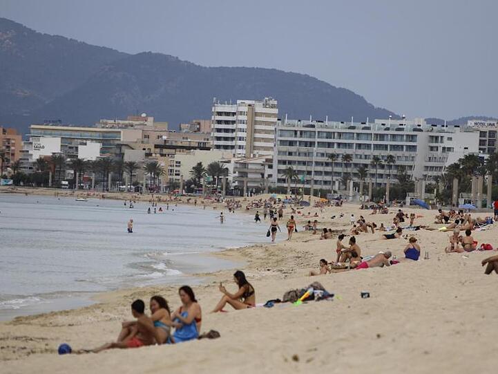 Menschen sonnen sich am Strand von Arenal auf Mallorca. Noch vor den Sommerferien soll die Reisefreiheit in der EU weitgehend zurückkehren.