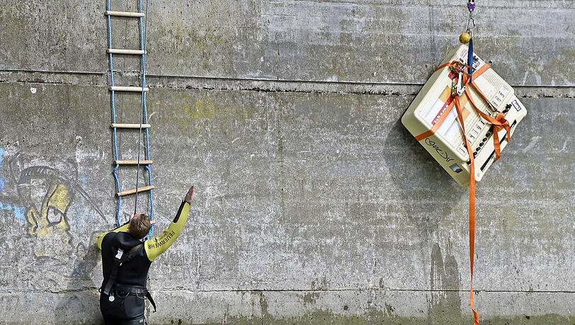 Ungewöhnlicher Einsatz für die Feuerwehr: Am Montagvormittag mussten sie einen Zigarettenautomaten aus der Isar bergen. Ungewöhnlicher Einsatz für die Feuerwehr: Am Montagvormittag mussten sie einen Zigarettenautomaten aus der Isar bergen.